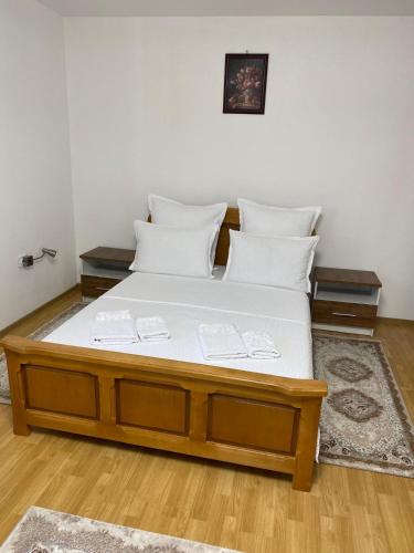 a bed with white sheets and pillows in a room at Casa Jeni in Suceava