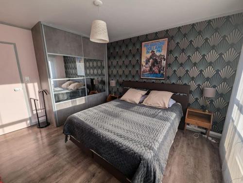 une chambre avec un lit et un mur dans l'établissement Logement 85m2, hypercentre, balcon, parking, clim, à Clermont-Ferrand