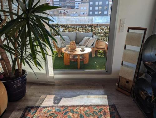 un salon avec une table et une plante en pot dans l'établissement Logement 85m2, hypercentre, balcon, parking, clim, à Clermont-Ferrand