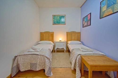 a room with two beds and a table in it at B&B Villa Botto in Cossato