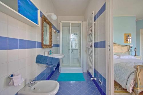 a blue and white bathroom with a sink and a bed at B&B Villa Botto in Cossato