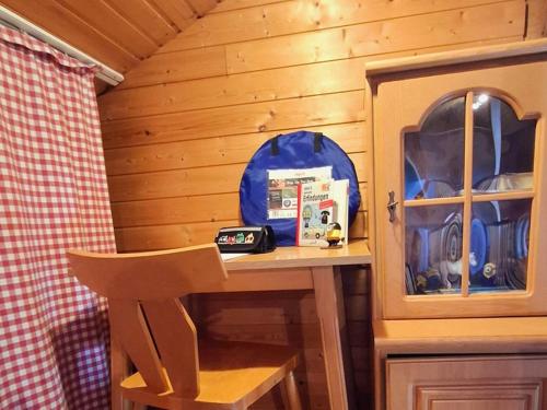 a wooden cabin with a table and a chair at Waldferienhaus 98 im bayerischen Waldferiendorf I 3 Schlafzimmer I Lagerfeuerplatz in Regen