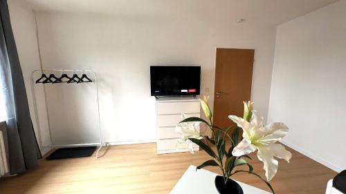 a living room with a television and a vase with flowers at Ruhige Monteur Wohnung in Bad Laer