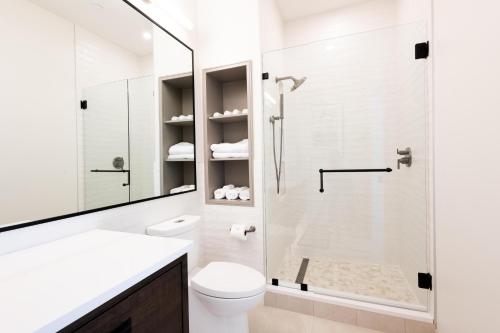 a white bathroom with a shower and a toilet at Southern Exposure at The Brent Lofts in Pensacola
