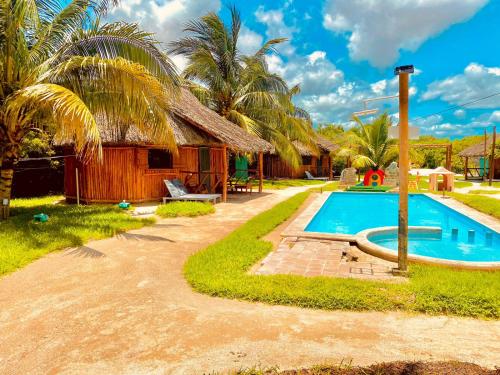 a resort with a swimming pool and a hut at Cabanas Jaalkab in Chelem