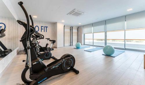 einen Fitnessraum mit einem Laufband und Heimtrainern in einem Raum in der Unterkunft Ático Ceitil Candor in Rota