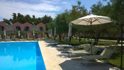 una piscina con tumbonas y sombrilla en Family Village Otranto, en Serra Alimini