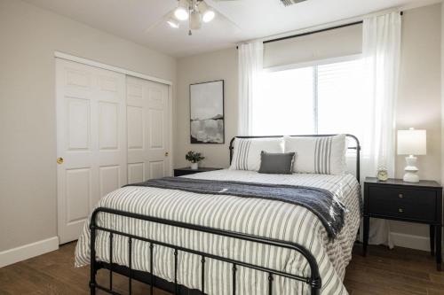a white bedroom with a bed and a window at Gilbert Douglas in Gilbert