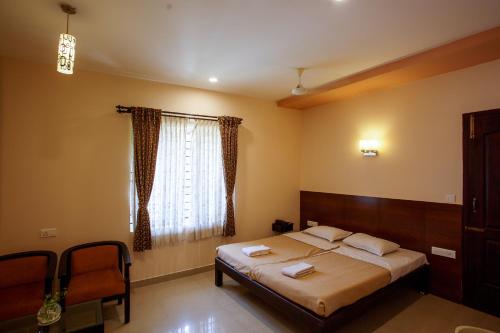 a bedroom with a bed and a window at Philomena Hotel & Apartment in Thanjāvūr