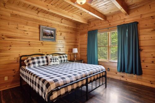 セバービルにあるGolden Grizzly Cabin W Hot Tub & Creek By Beyondの丸太小屋のベッドのある寝室