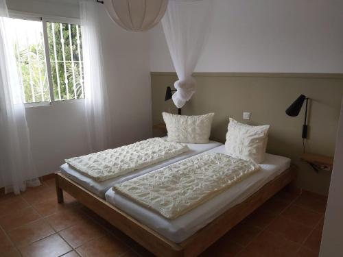 a bedroom with two beds with white sheets and a window at Casa los Limones Torrox in Torrox