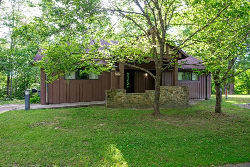 a house with a tree in front of it at Cumberland Falls State Resort Park in Honeybee
