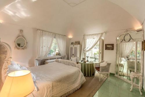 Un dormitorio con una cama, una mesa y un espejo. en Villa Felicia, en Capri
