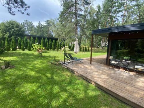 a house with a wooden deck in a yard at Jaunjespari 1 in Batciems