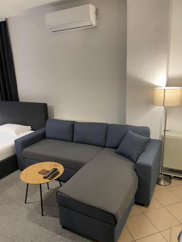 un soggiorno con un divano blu e un tavolo di Friendly Rent a Pristina