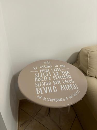 a white table with writing on it next to a couch at Sweet home in Ciampino