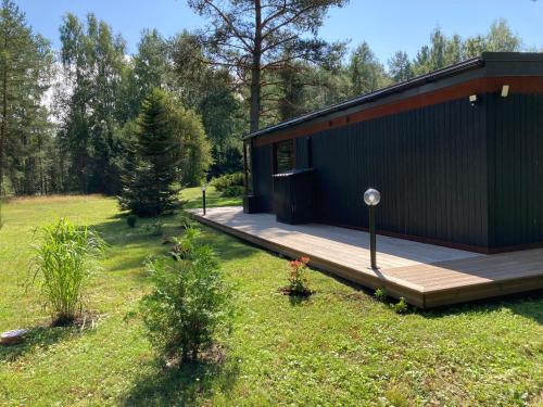 a house with a wooden deck in a field at Jaunjespari 1 in Batciems