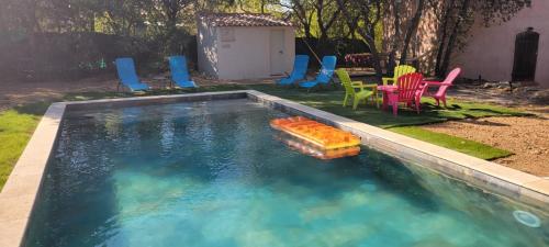 ein Pool mit Stühlen und einem Spielzeug im Wasser in der Unterkunft Mazet in Rognes