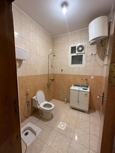 a small bathroom with a toilet and a microwave at اجنحة ارتياد للشقق المخدومه in Abha