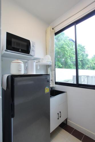 a small kitchen with a refrigerator and a microwave at Homeku Guesthouse Room 1 near airport at Latkrabang in Lat Krabang