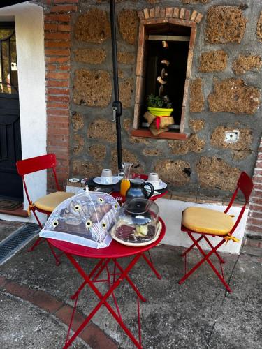 een tafel met een bord eten en twee stoelen bij Cottage Apanu in Viterbo