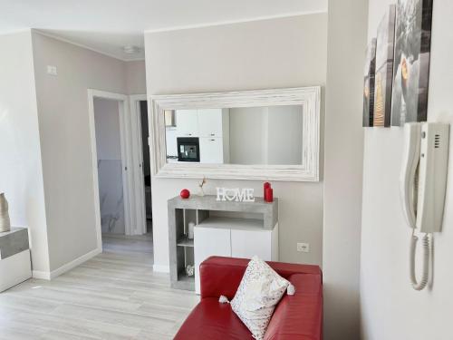 a living room with a red couch and a mirror at Relais Verde Casa in Trecastelli
