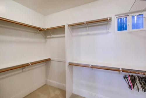 a walk in closet with white walls and wooden shelves at Villa Andalusia 6BR 5BA Luxury Jacuzzi Views and Games in Escondido
