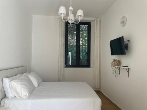 a white bedroom with a bed and a window at VILLA SIMONA Malpensa in Gallarate