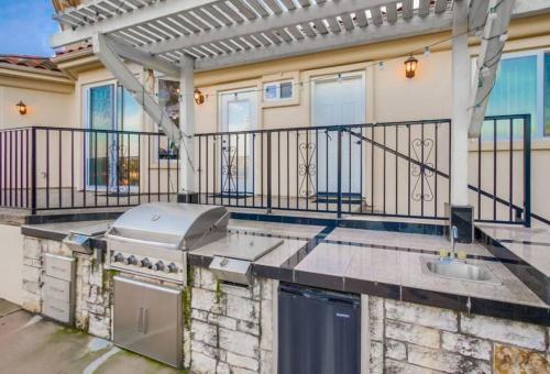an outdoor kitchen with a grill on a house at Villa Andalusia 6BR 5BA Luxury Jacuzzi Views and Games in Escondido