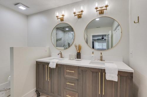 a bathroom with two sinks and two mirrors at Lutz Home with Game Room 7 Mi to Adventure Island! in Lutz