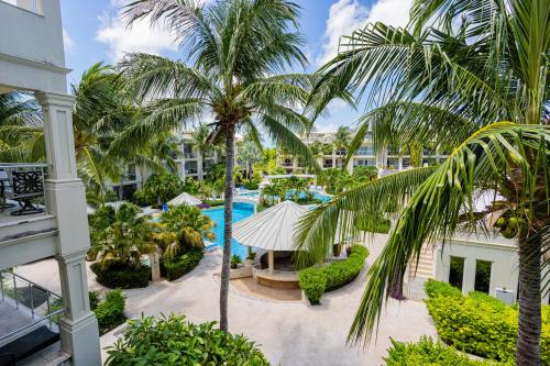 an aerial view of a resort with a pool and palm trees at The Atrium Resort in Grace Bay