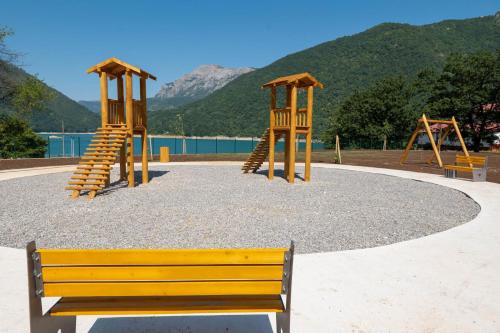 a park with two swings and a bench at Apartman PAVLE in Pluzine