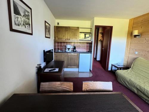 un salon avec un canapé et une cuisine dans l'établissement Résidence Quartz - 2 Pièces pour 4 Personnes 25, à Mâcot La Plagne