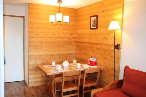 une salle à manger avec un mur en bois dans l'établissement Résidence Themis - Studio pour 4 Personnes 21, à Mâcot La Plagne