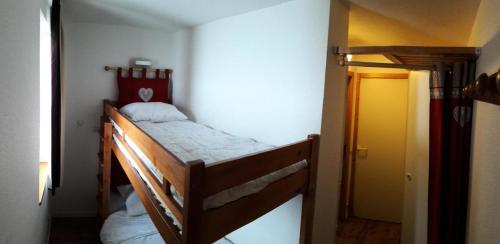 Ce lit superposé se trouve dans un dortoir doté d'une porte jaune. dans l'établissement Résidence Themis - Studio pour 4 Personnes 21, à Mâcot La Plagne