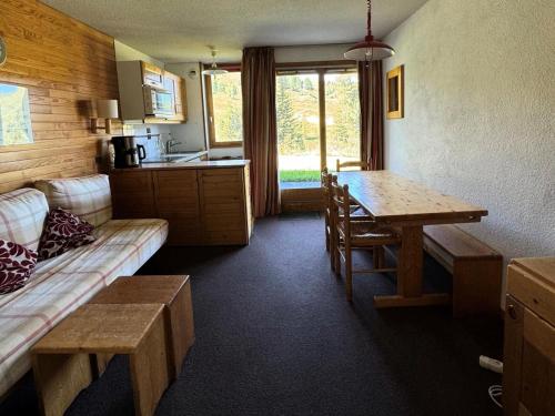 un salon avec un canapé et une table et une cuisine dans l'établissement Résidence Turquoise - 2 Pièces pour 5 Personnes 97, à Mâcot La Plagne