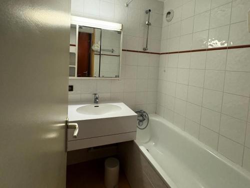 une salle de bain avec un lavabo, une baignoire et un miroir dans l'établissement Résidence Turquoise - 2 Pièces pour 5 Personnes 97, à Mâcot La Plagne