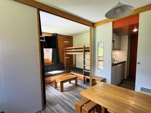 Cette petite maison dispose d'une table à manger et de lits superposés. dans l'établissement Résidence Aigue-marine - Studio pour 4 Personnes 83, à Mâcot La Plagne