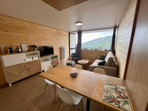 Cette chambre comprend une table à manger et un salon. dans l'établissement T2 avec Parking - Centre station - SUPER BESSE, à Besse-et-Saint-Anastaise