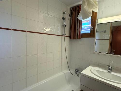 une salle de bain avec une baignoire et un lavabo dans l'établissement Résidence Turquoise - 2 Pièces pour 5 Personnes 93, à Mâcot La Plagne