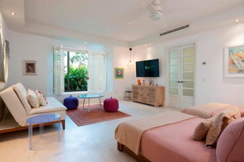 a living room with two beds and a tv at Great Family-Friendly condo inside the gates in Punta Mita