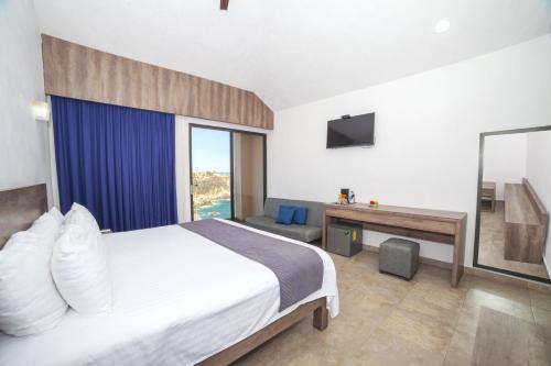 a hotel room with a bed and a television at Coral Blue Huatulco All Inclusive in Santa Cruz Huatulco