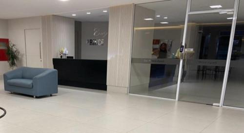 a lobby with a blue chair in a building at AP confortável e bem localizado in Vitória