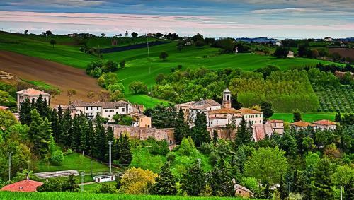 a town in the middle of a green field at Relais Verde Casa in Trecastelli