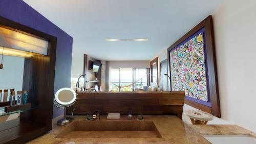 a bathroom with a tub and a large window at Hotel Xcaret Arte - All Parks All Fun Inclusive - Adults Only in Playa del Carmen