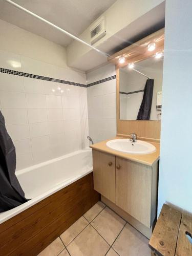 une salle de bain avec un lavabo, une baignoire et un miroir dans l'établissement Résidence Le Schuss 1 - Grande terrasse sud au pied des pistes de l'Espace Diamant MAE-3204, à Notre-Dame-de-Bellecombe