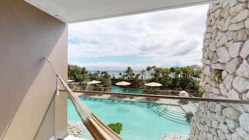 a view of the pool from the balcony of a resort at Hotel Xcaret Arte - All Parks All Fun Inclusive - Adults Only in Playa del Carmen