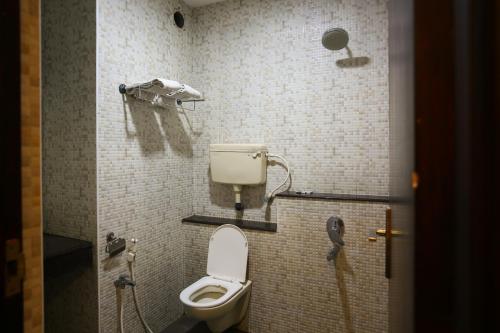 a bathroom with a toilet and a shower at Philomena Hotel & Apartment in Thanjāvūr