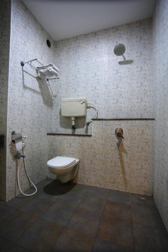 a bathroom with a toilet and a phone at Philomena Hotel & Apartment in Thanjāvūr