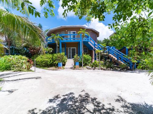 a house on the beach with a palm tree at White Sands Cove G04- Partial Ocean View 1 BR by Stay Floreo in San Pedro